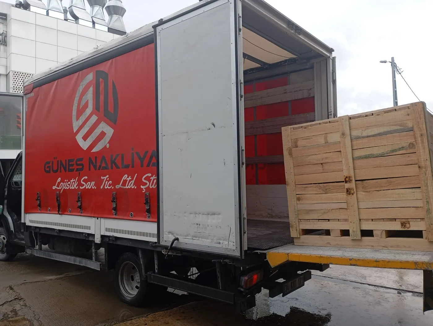 Güneş Nakliyat liftli kamyonuna hidrolik lift üzerinden ahşap sandık yüklenmesi
